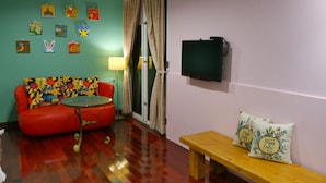 A room with a red sofa, a small round table, a wooden bench, and a TV on the wall. - Pottery B&B (Jiaoxi)
