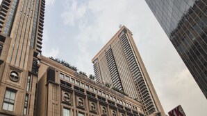 A high-rise building with a modern architectural design, featuring multiple floors and a prominent central tower. - Queens Service Suite at Times Square (Kuala Lumpur)