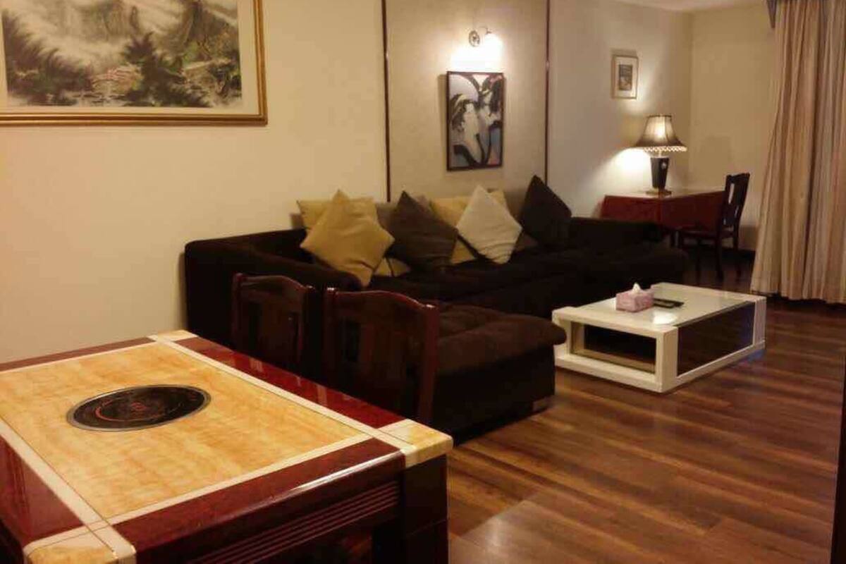 A living room with a wooden dining table, a sofa, and a coffee table.