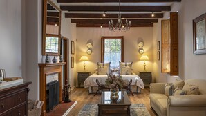 Une chambre de style traditionnel, dotée d’une cheminée, d’un lit et d’un lustre.