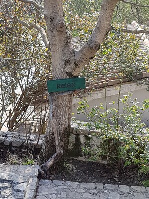 A tree with a sign that reads "Relax" attached to it. - Locanda Colle Cerqueto (Petrella Salto)