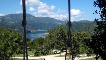 Une balançoire donnant sur un lac, avec des montagnes en arrière-plan.