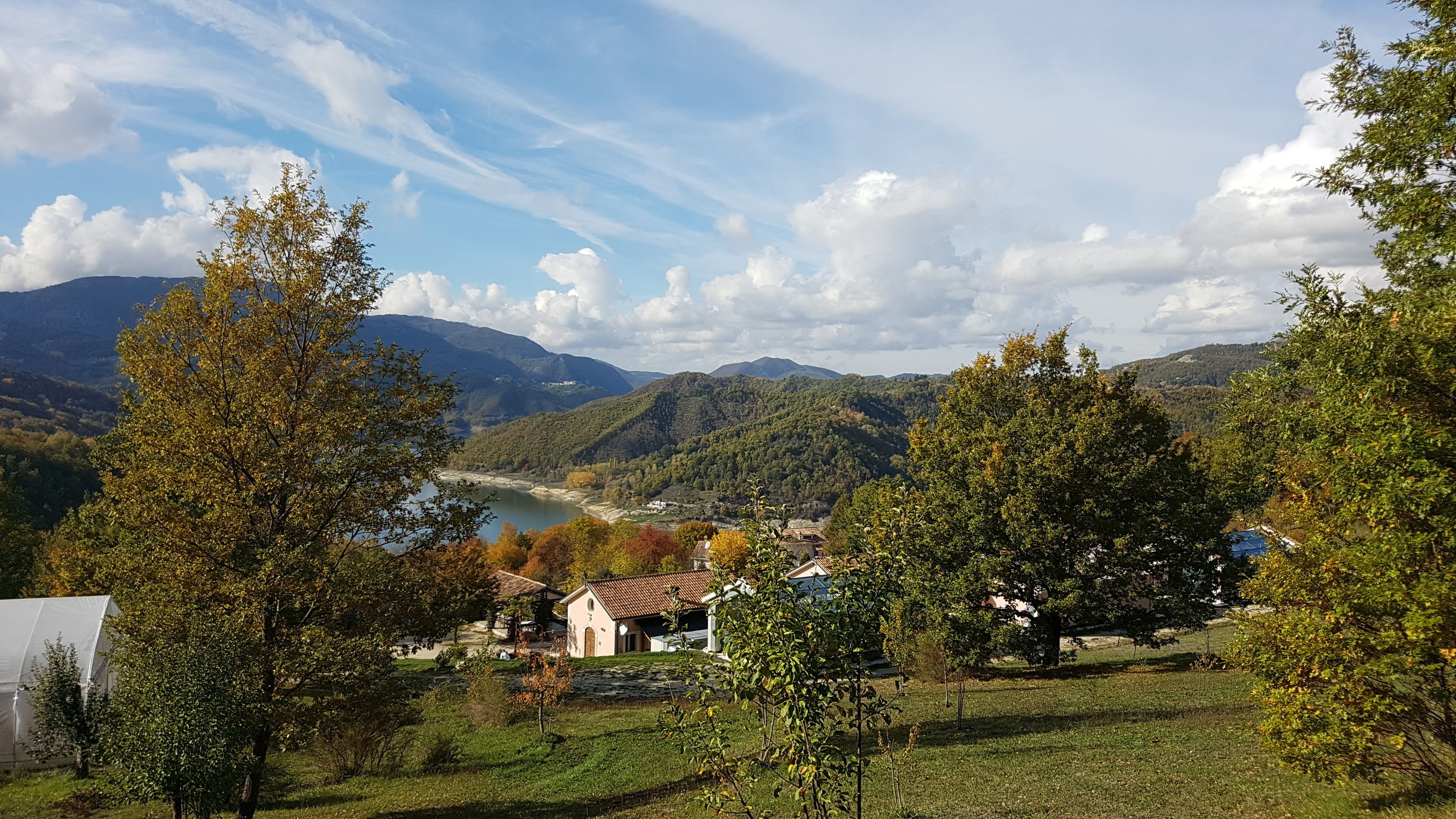 Ett lantligt landskap med en flod, berg och en liten by.