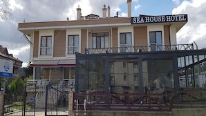 A two-story building with a sign reading 'SEA HOUSE HOTEL' and a covered entrance area.