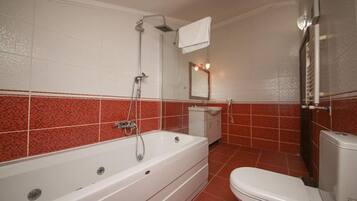 Un baño con bañera, inodoro y lavabo.