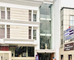Un hotel con fachada moderna, ventanas amplias y una estatua en el balcón.