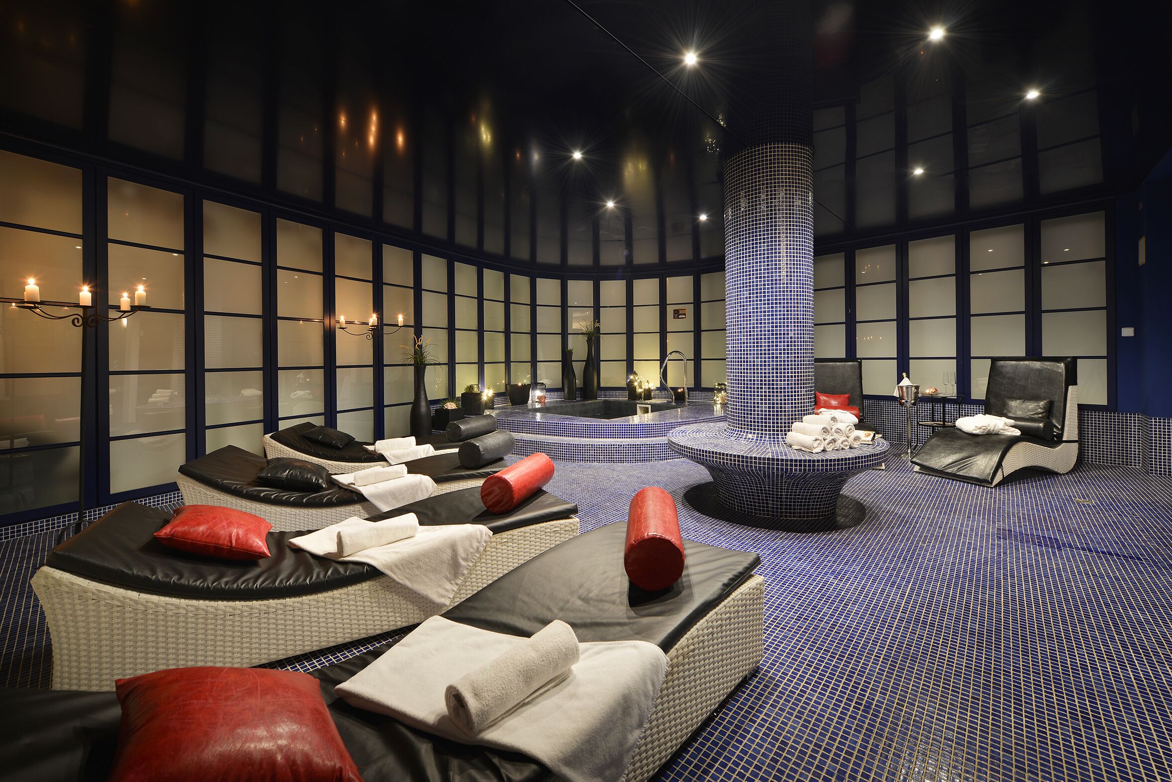 A spa room with massage chairs, a central water feature, and a patterned floor.