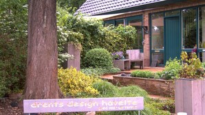 A garden with a sign that reads "dents design havenette." - B&B Op de Parkkamp (Havelte)