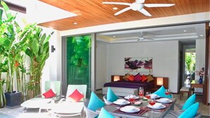 Uma área de refeições moderna com piscina, assentos externos e vista para o quarto.