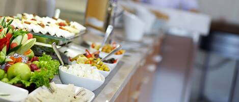 A buffet with various food items including fruits, cheeses, and salads.