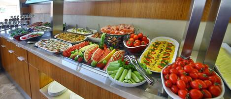 A buffet with various food items including salads, fruits, and vegetables.