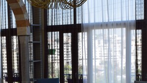 A spacious room with a large window, a red rug, and two chairs. - Warda وَرْدَة Lebanese Guesthouse (Zouk Mosbeh)
