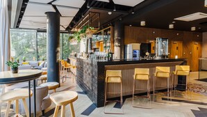 Un espace bar moderne doté d’un comptoir central, de tabourets de bar et de différents types de sièges.