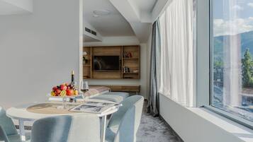 Un comedor moderno con una mesa redonda, sillas tapizadas en azul claro y un frutero sobre la mesa.
