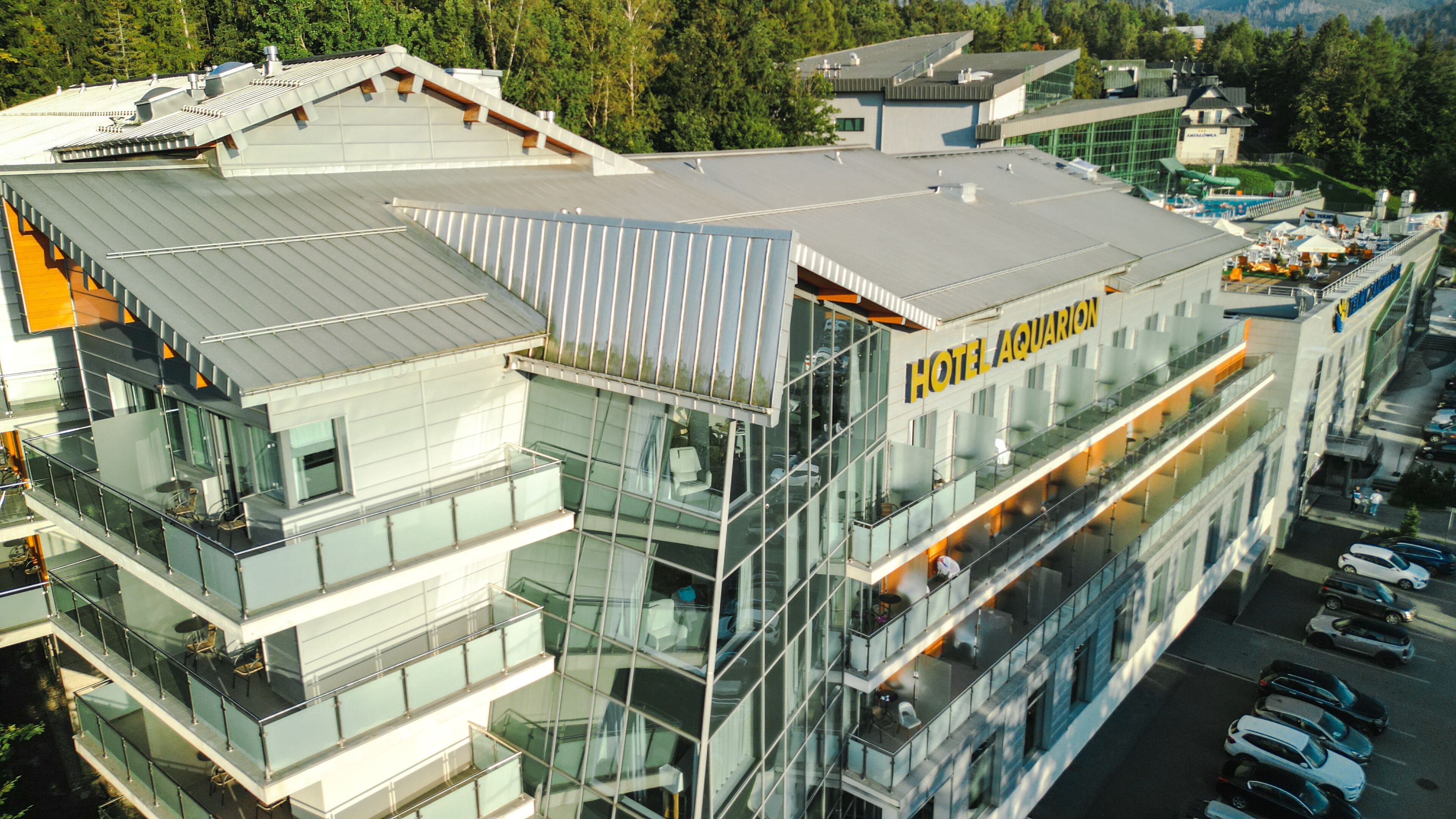 A modern hotel with multiple floors, large glass windows, and a prominent "HOTEL AQUARION" sign.