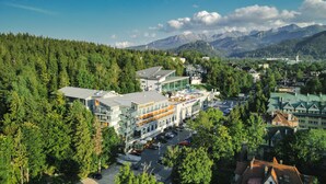 Un hôtel à plusieurs étages, doté d’une piscine et offrant une vue sur les montagnes.