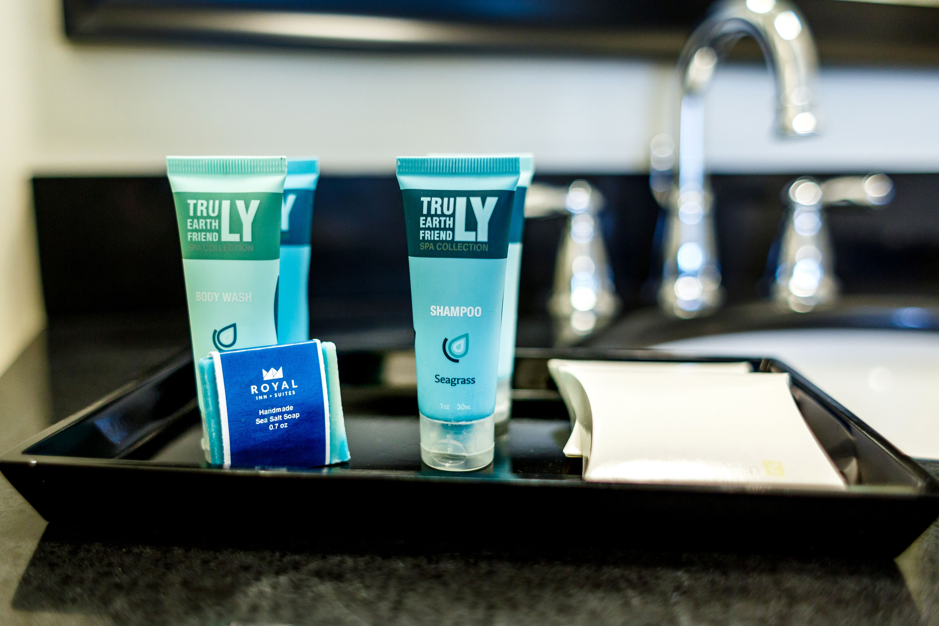 A bathroom counter with toiletries including body wash, shampoo, and hand soap.