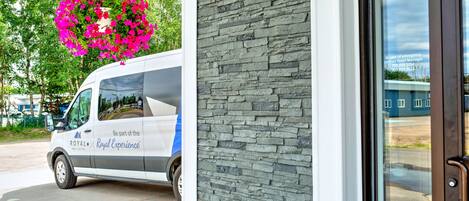A white van parked outside a building with a stone facade.