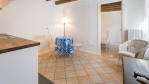 A compact kitchen with a wooden countertop and a dining area with a table and chairs. - Suite del Doge 2 (Verona)