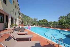 A swimming pool with lounge chairs and a pink flamingo float. - Hotel Roè Garda (Roe Volciano)