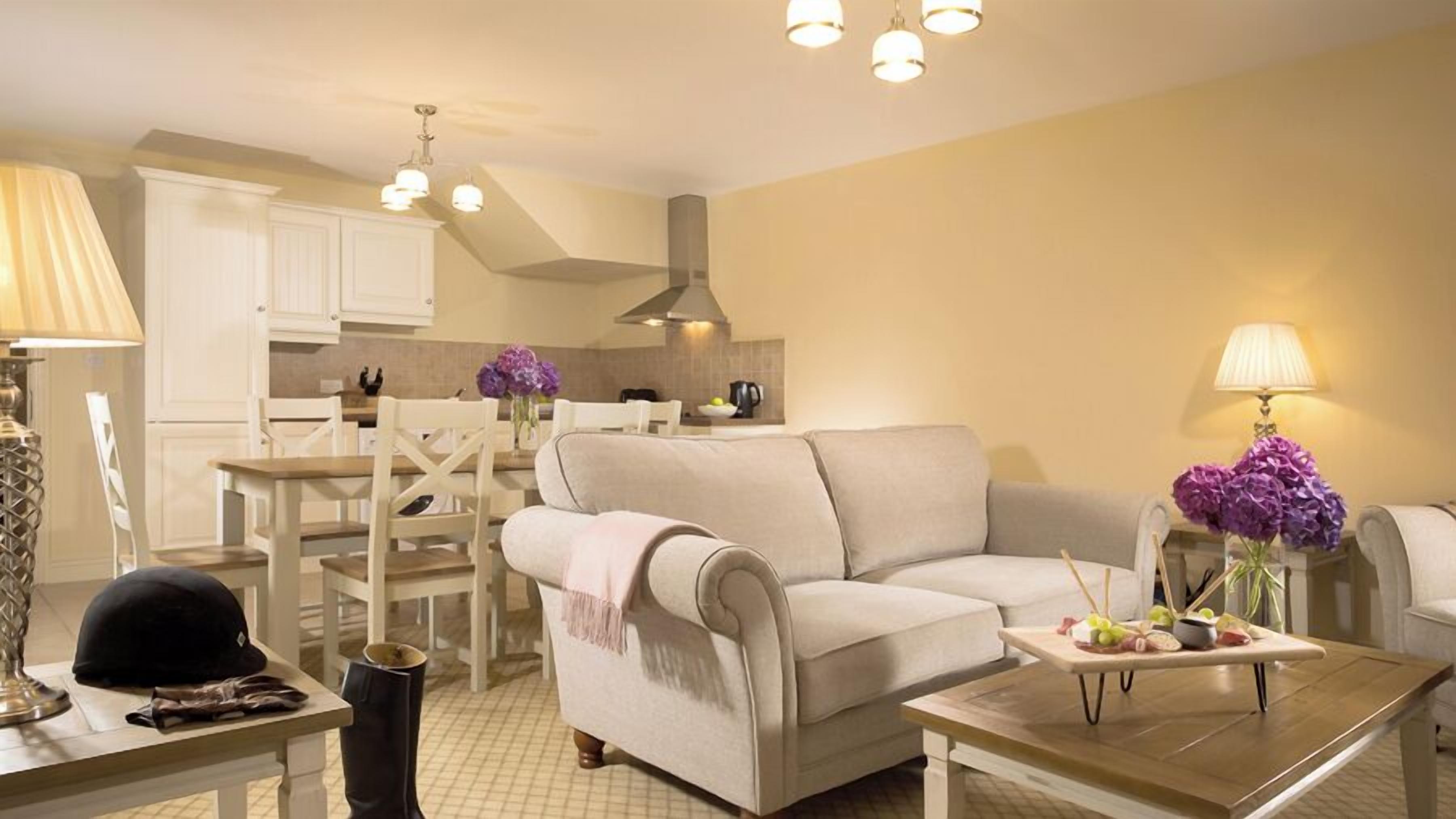 A living room with a sofa, coffee table, and dining area with chairs and a table.