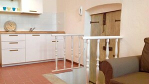 A kitchen with white cabinets, a wooden countertop, and a white railing. - Suite Elda (Verona)