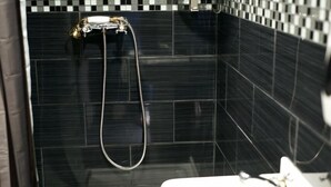 A bathroom with black tiled walls and a shower area. - Hostel Galia (Brussels)