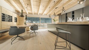 Una cocina moderna con vigas de madera, una zona de bar y taburetes.