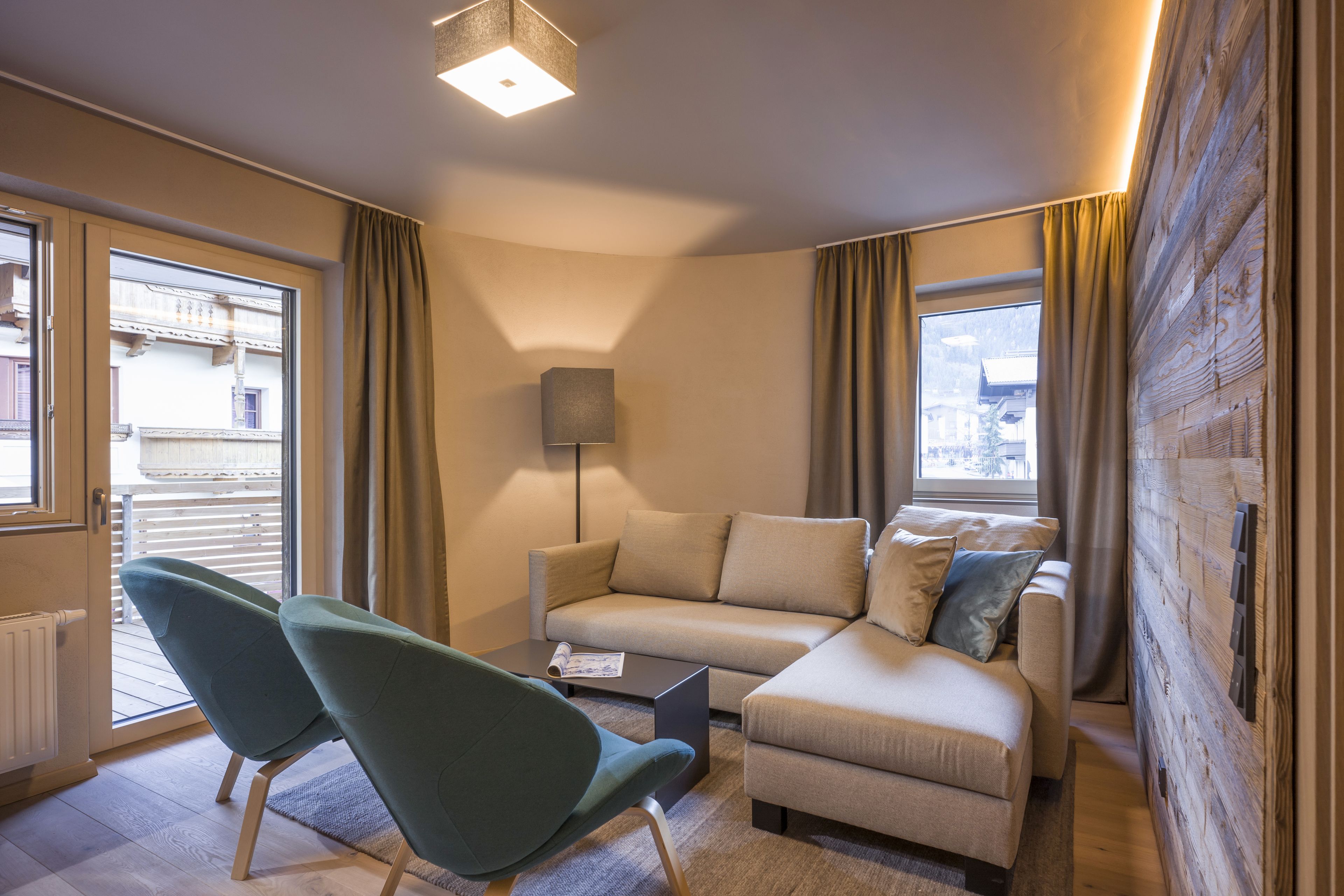 Una sala de estar moderna con un sofá, dos sillones, una mesita de centro y una lámpara de pie.