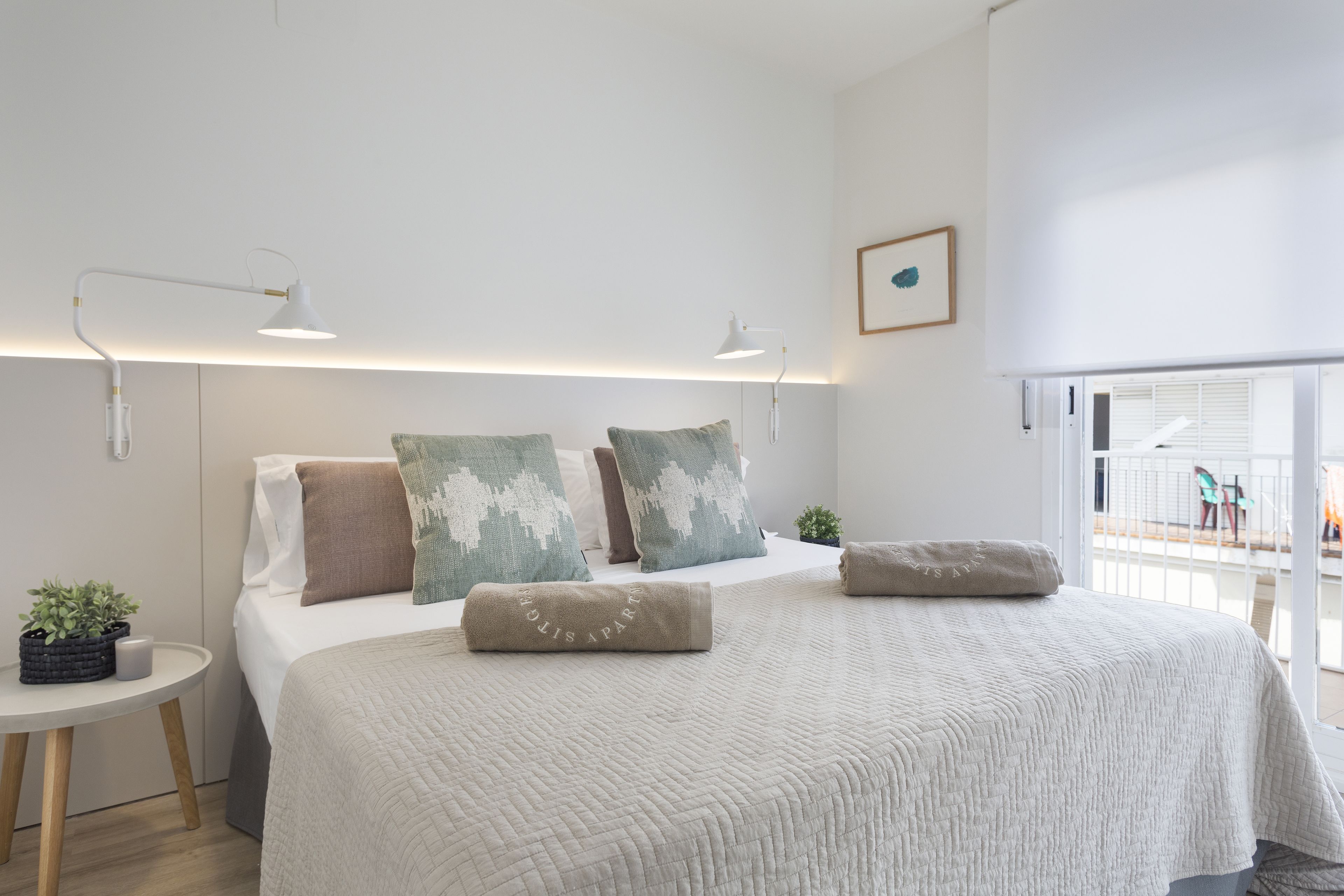 Une chambre moderne avec un grand lit, des tables de chevet et un balcon offrant une belle vue.