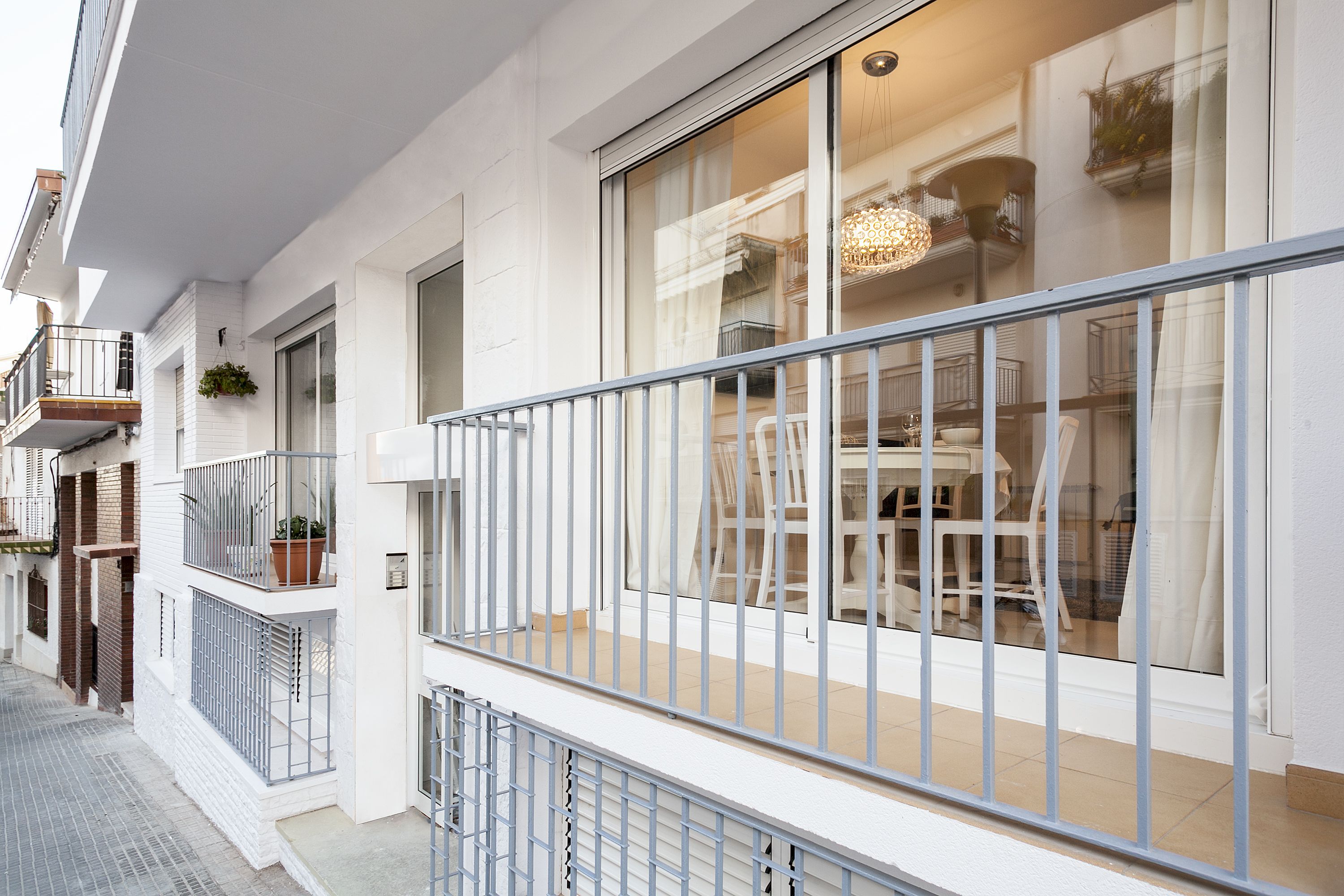 Eine moderne Wohnung mit Balkon, großen Fenstern und einer hellen, weißen Fassade.