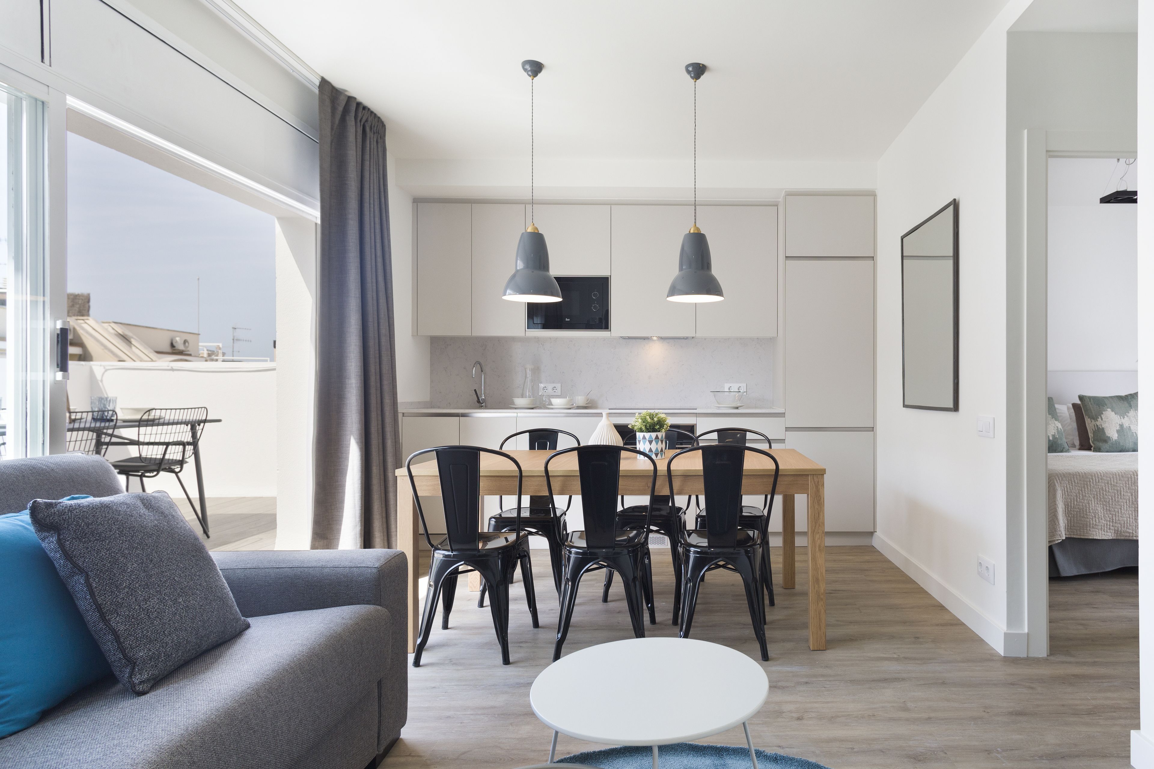 A modern apartment with a dining area, kitchen, and living space.