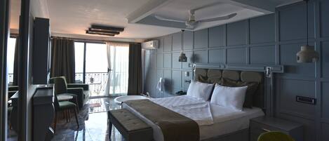 Una habitación de hotel con una cama grande, un escritorio, una silla y un balcón con vistas.