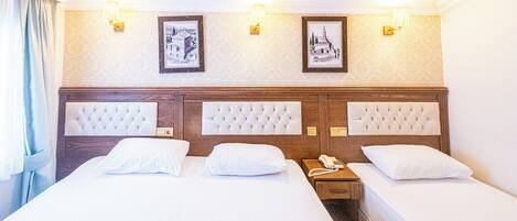 A hotel room with a large bed, two bedside tables, and a nightstand with a phone.