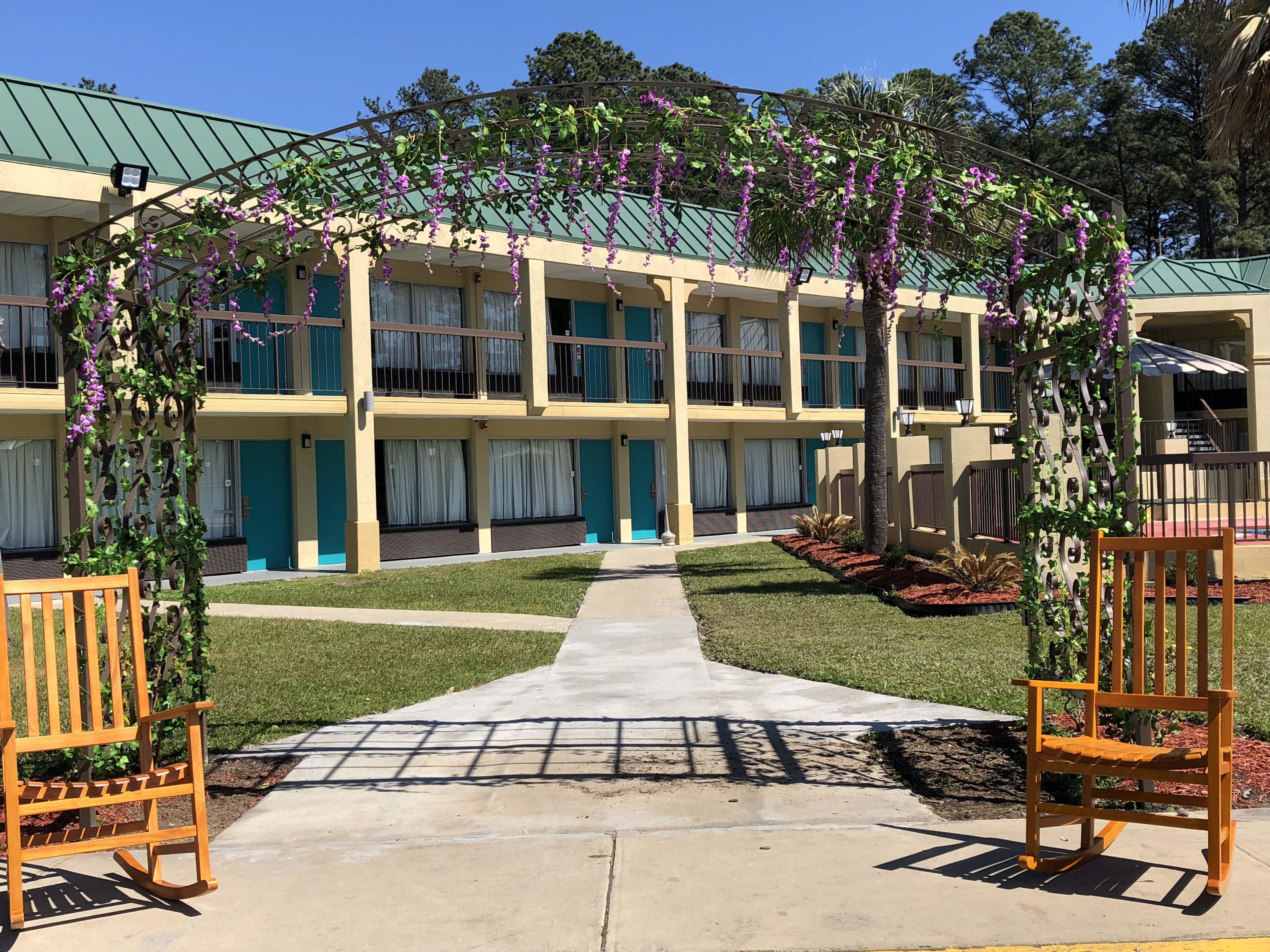 Un hotel con paseo techado, zona de estar exterior y tejado ajardinado.
