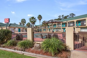 Un motel con varios balcones, una zona de piscina y un cartel de Econo Lodge.