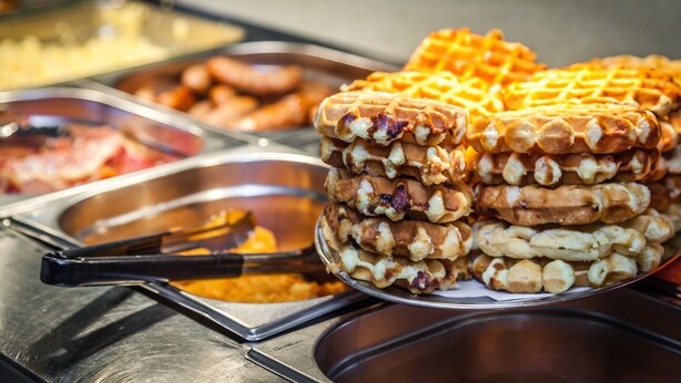 A stack of waffles with nuts on a metal tray. - Econo Lodge Inn & Suites Hardeeville I-95 (Hardeeville)