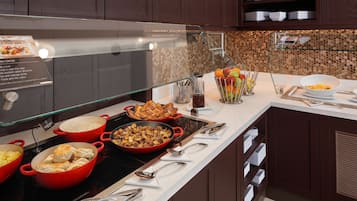 Disposição de buffet com diversos pratos e utensílios.