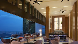 A rooftop bar with seating, a bar area, and a view of the cityscape.