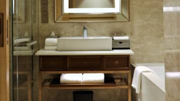 A modern bathroom with a glass shower enclosure, a large mirror, a sink, and a bathtub.
