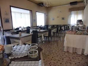 A dining area with multiple tables, chairs, and a buffet setup. - Mayer (Jesolo)