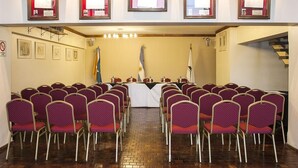 A conference room with a long table and rows of chairs, framed pictures on the walls, and a staircase to the right. - Atlantida Hotel (Río Grande)