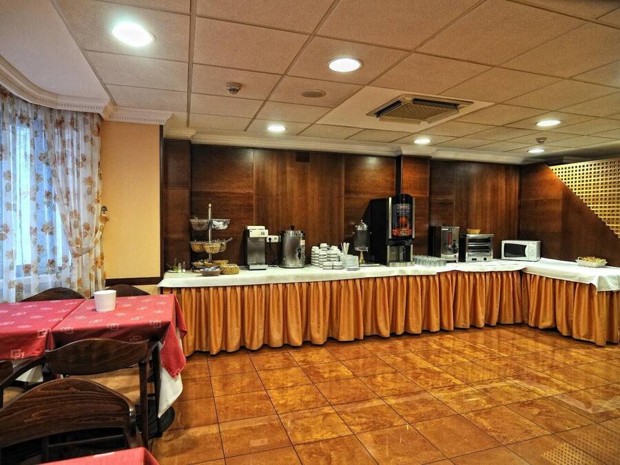 Une salle de conférence équipée d’une longue table, de machines à café et d’un buffet.