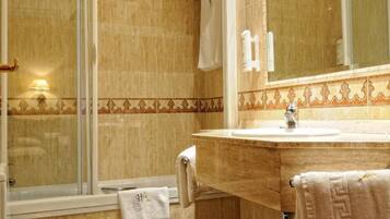 Un baño con inodoro, lavamanos y ducha.
