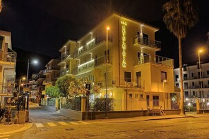 Un hotel de varios pisos con balcones y un letrero que dice 'HOTEL MIRIAM'.