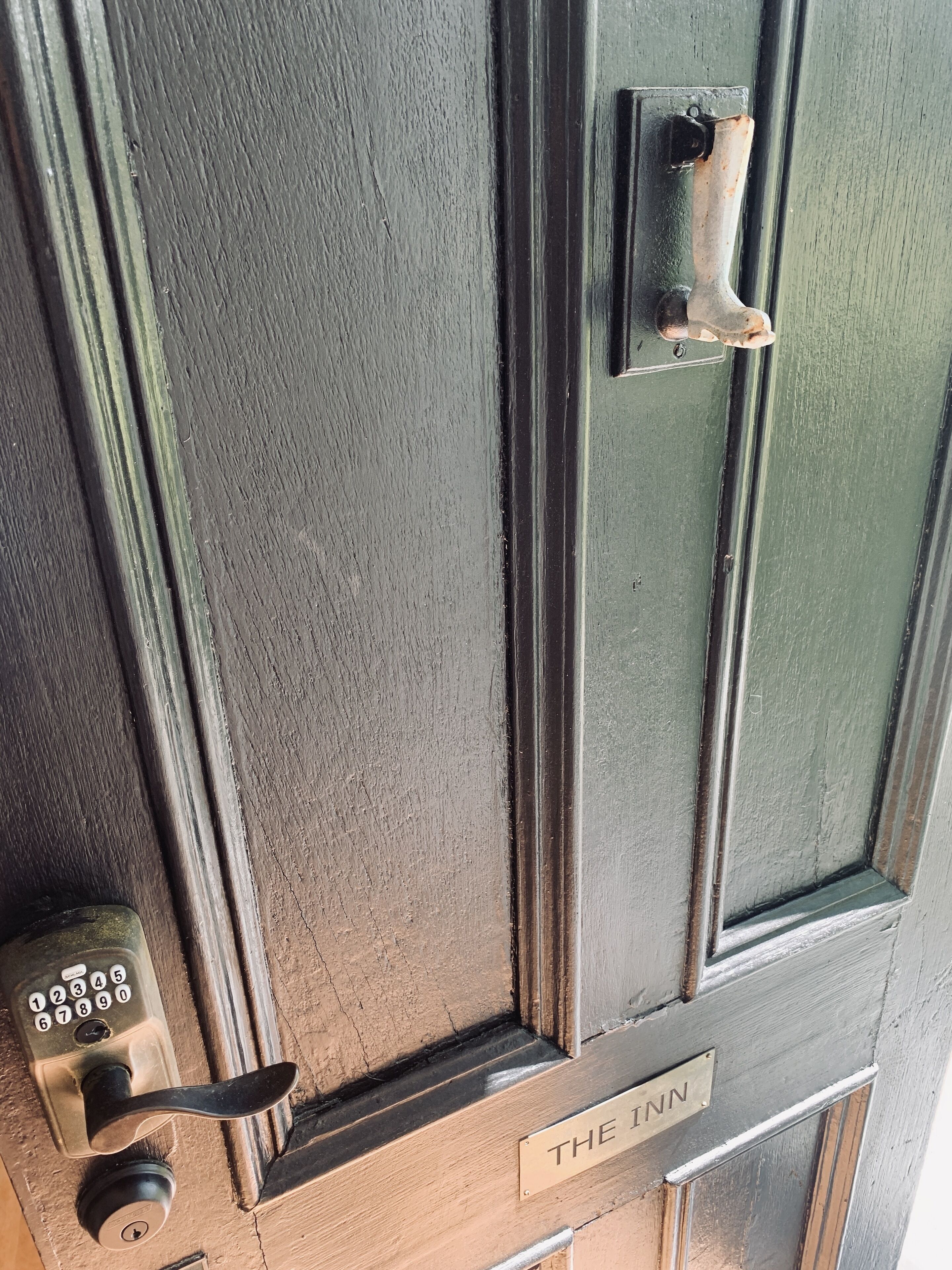 A door with a numeric keypad lock, a keyhole, and a sign that reads "THE INN".