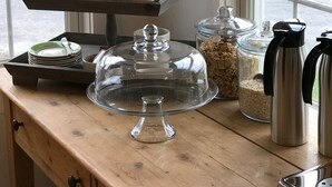 A breakfast setup with a tiered tray holding fruits, cups, and a coffee pot. - The Orchard House: Inn & Cafe (Freeport)