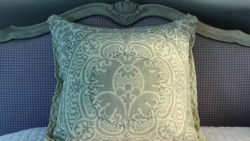 A bed with a patterned pillow and a headboard with a floral design.