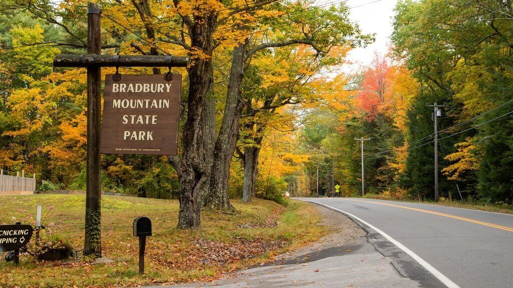 A road sign for Bradbury Mountain State Park with a mailbox and a mailbox slot on the side of the road.