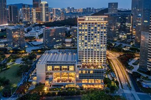 A high-rise hotel with a modern design, featuring multiple floors with illuminated windows, surrounded by a cityscape. - Shangri-La Xiamen (Xiamen)